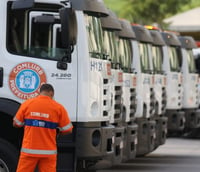 Gari da Comlurb em frente a caminhões da Companhia (Foto: Prefeitura do Rio de Janeiro)